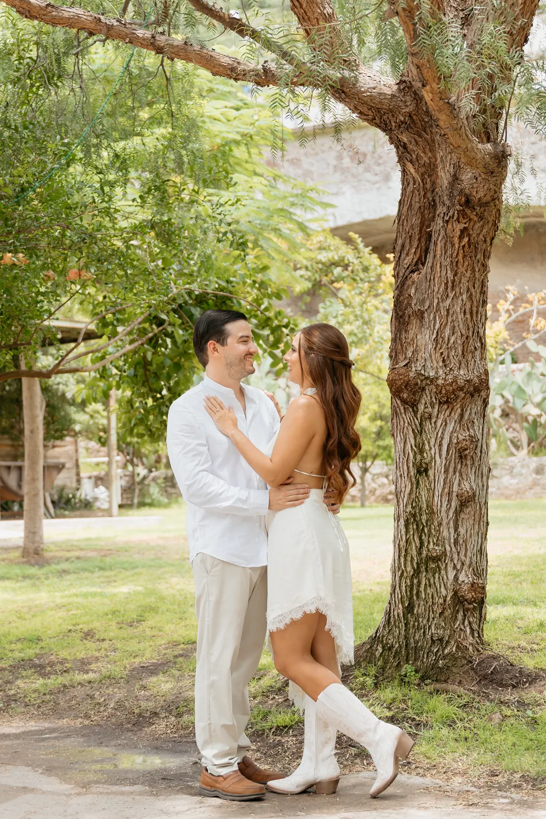Valeria y Andrés abrazados bajo un árbol